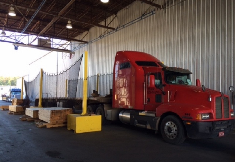 Portable flatbed truck netting in use at outdoor fulfillment centre